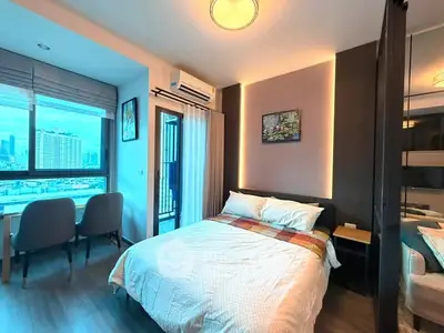 Modern bedroom with city view, stylish decor, and cozy ambiance in urban apartment.