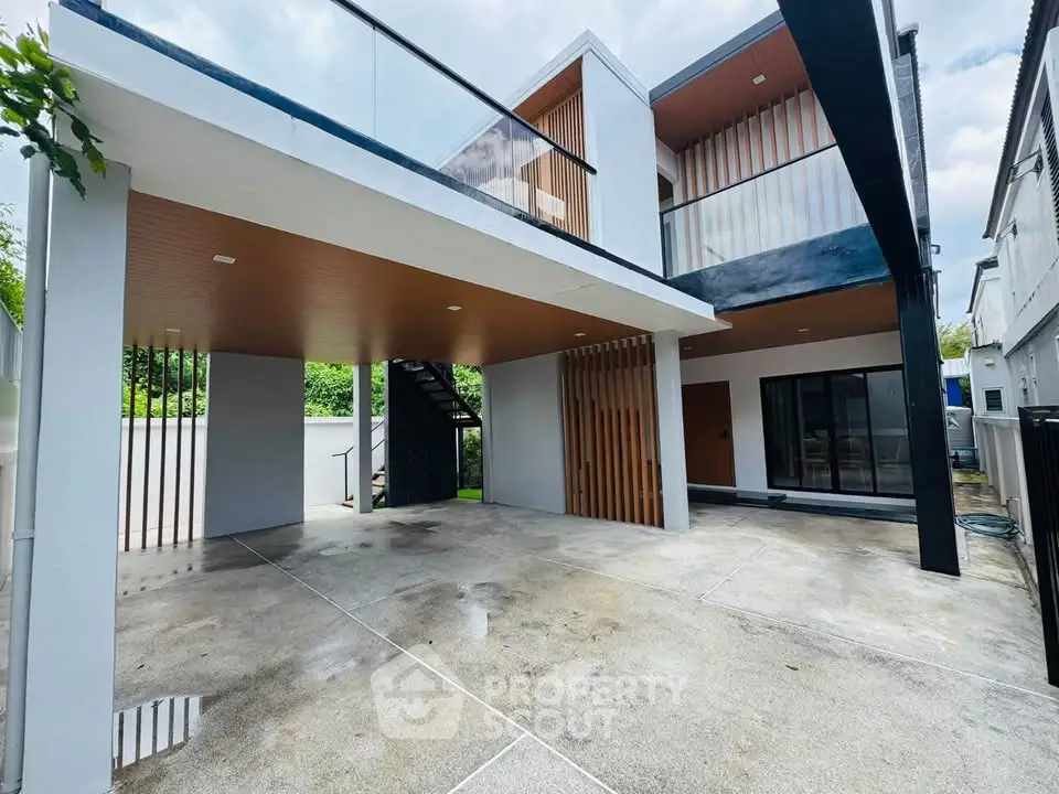 Modern two-story house with sleek design and spacious carport in a serene neighborhood.