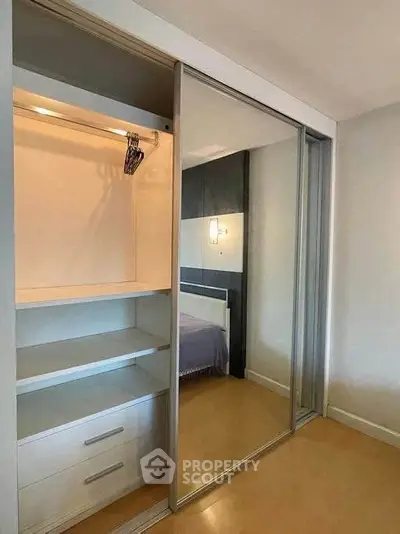 Spacious bedroom with mirrored sliding closet doors and ample storage space.