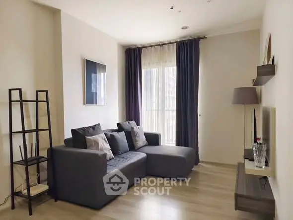 Modern living room with stylish gray sofa and floor-to-ceiling window for natural light.