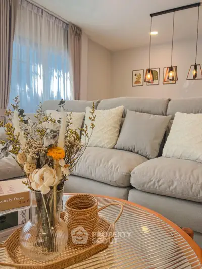 Cozy living room with plush sofa, elegant lighting, and decorative accents for a warm ambiance.