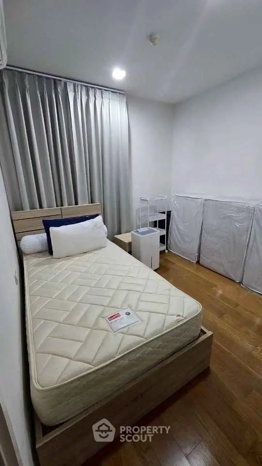 Cozy bedroom with wooden flooring and modern furnishings, perfect for a restful retreat.