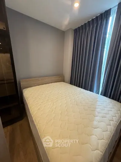 Cozy bedroom with natural light and modern furnishings in a stylish apartment.