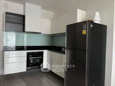 Modern kitchen with sleek black appliances, glossy white cabinetry, and a dark countertop, perfect for culinary enthusiasts.