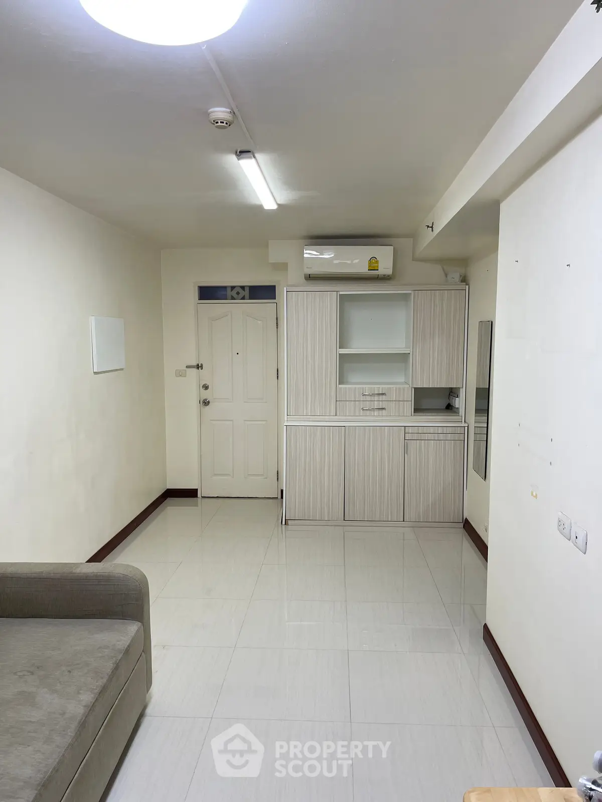 Spacious living room with modern minimalist design and air conditioning unit.