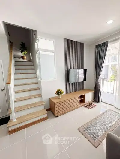 Modern living room with sleek staircase and natural light
