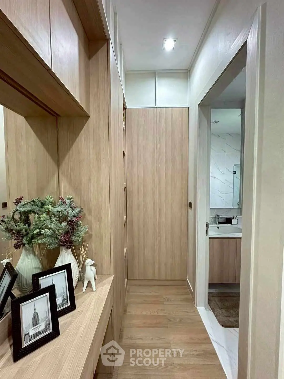 Elegant hallway with wooden cabinetry leading to a modern bathroom