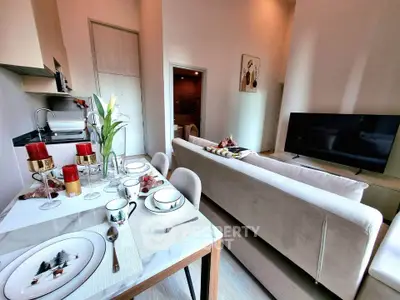 Modern living room with elegant dining setup and cozy seating area, perfect for entertaining guests.
