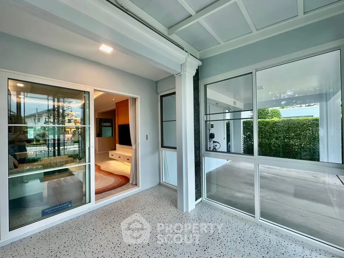 Modern home with spacious patio and large glass doors leading to a cozy living room.