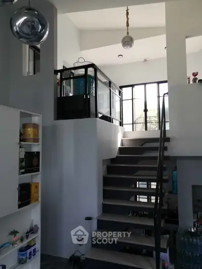Modern multi-level interior with sleek staircase and large windows