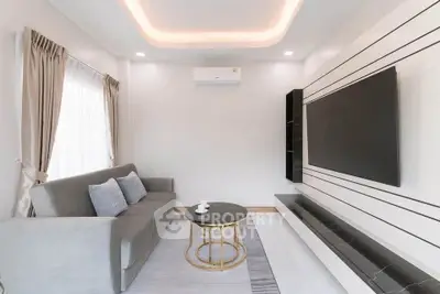 Modern living room with sleek design, featuring a large TV and comfortable sofa.