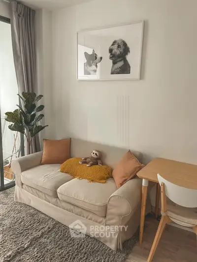 Cozy living room with beige sofa, stylish decor, and natural light from balcony.