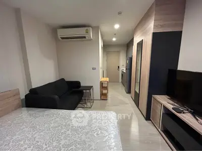 Modern studio apartment with sleek furniture and air conditioning, perfect for urban living.