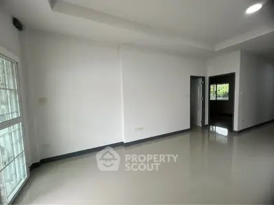 Spacious empty room with large windows and glossy tiled floor, perfect for customization.