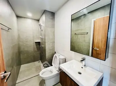 Modern bathroom with sleek design, featuring a spacious shower and contemporary fixtures.