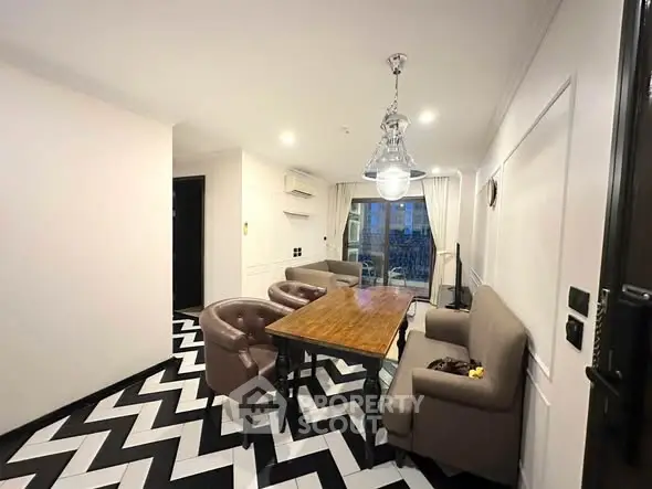 Stylish dining area with modern chevron flooring and elegant lighting in a cozy apartment.