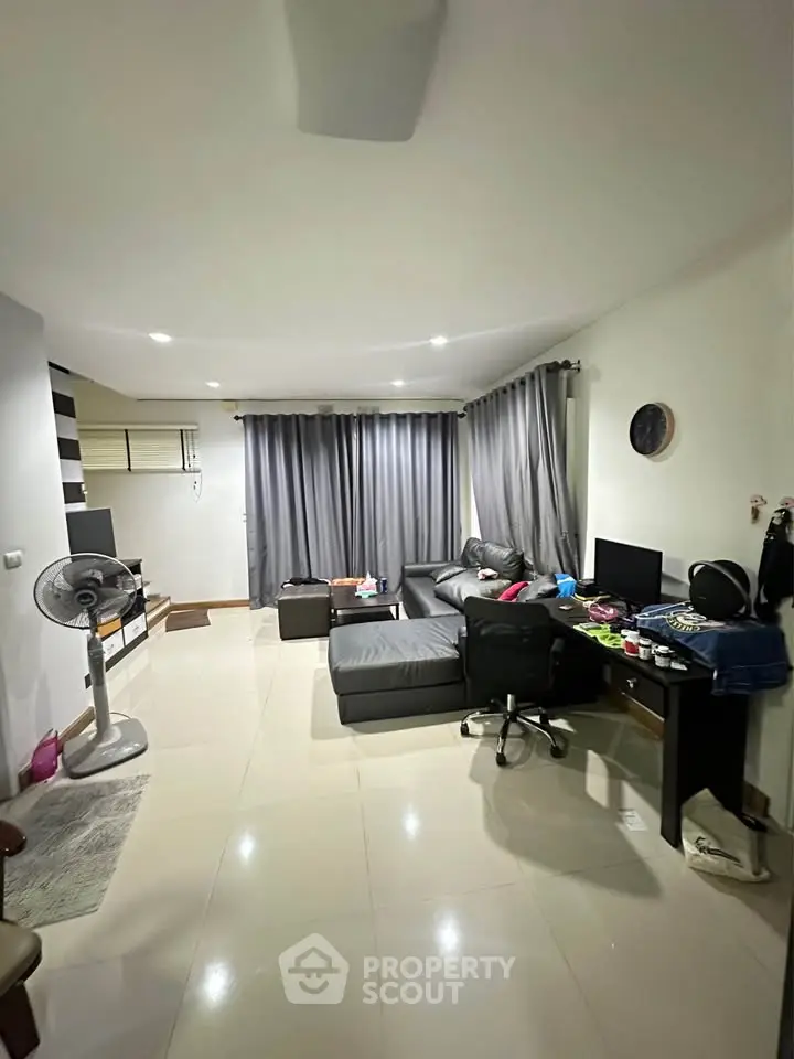 Spacious living room with modern decor and ample natural light, perfect for relaxation and entertainment.