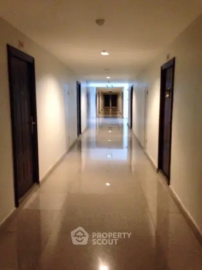 Spacious apartment hallway with polished floors and modern lighting