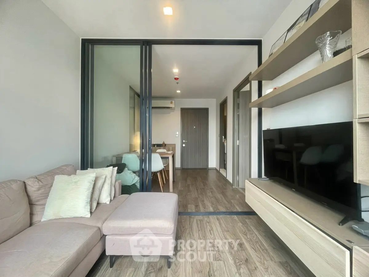 Modern living room with stylish decor and open layout, featuring a cozy sofa and sleek TV unit.
