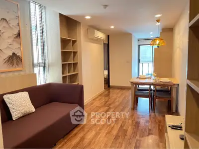 Modern living room with dining area and wooden flooring in cozy apartment