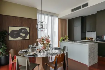 Modern dining area with stylish decor and open kitchen layout in a luxury apartment.
