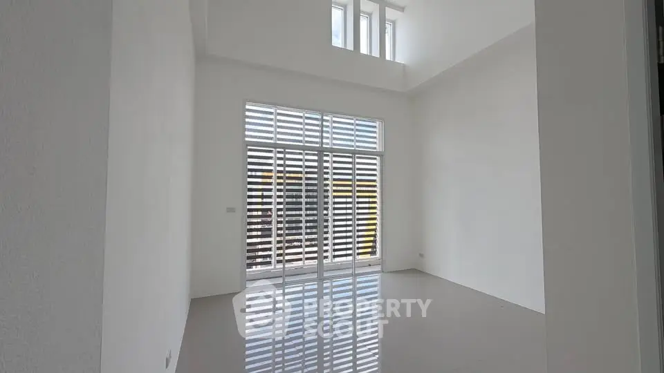 Spacious modern living room with high ceilings and large windows offering abundant natural light.