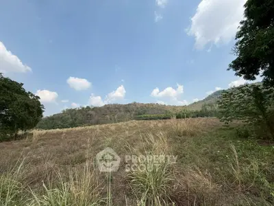 Expansive land with scenic mountain views under a clear blue sky, perfect for development.