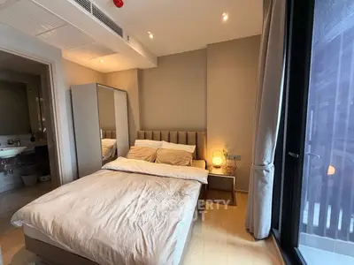 Modern bedroom with cozy lighting and large window in luxury apartment