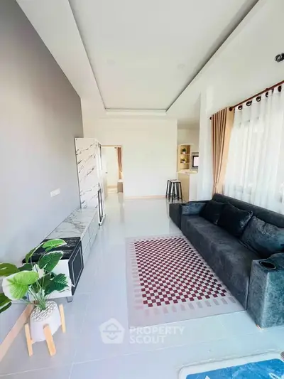 Modern living room with stylish decor, large windows, and comfortable seating in a bright open space.