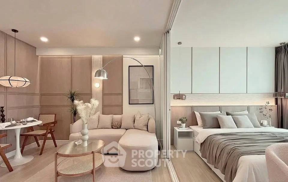 Modern open-plan living room and bedroom with elegant decor and neutral tones.