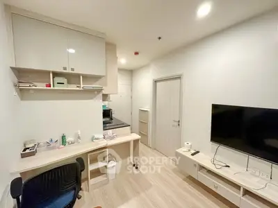 Modern living room with sleek furniture and wall-mounted TV in a cozy apartment.