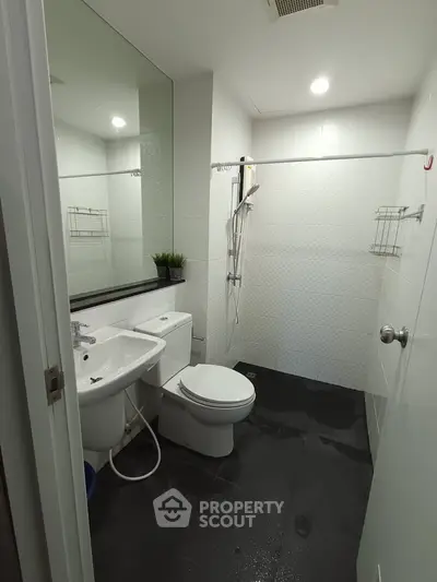 Modern bathroom with sleek fixtures and large mirror in contemporary apartment.
