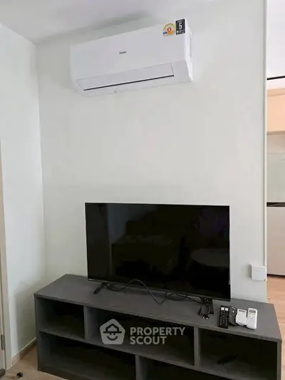 Modern living room with air conditioner and TV setup, perfect for relaxation.