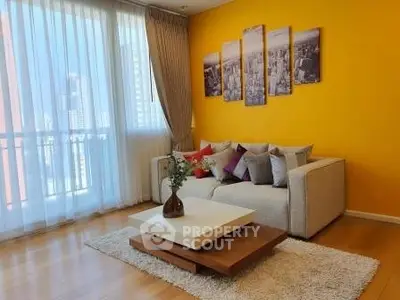 Stylish living room with vibrant yellow accent wall and cityscape artwork, featuring cozy sofa and modern coffee table.