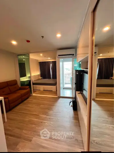 Modern studio apartment with cozy living area and balcony view