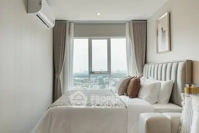 Modern bedroom with city view, featuring elegant decor and natural light.