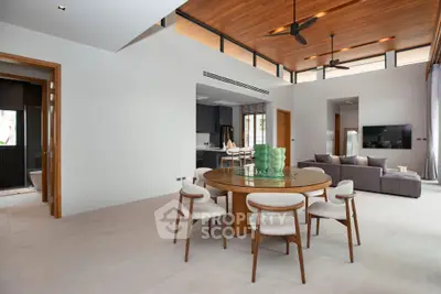 Luxurious open-plan living room with modern dining area and high ceilings