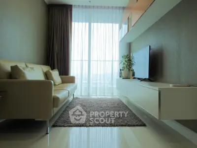 Modern living room with sleek furniture and large window view.