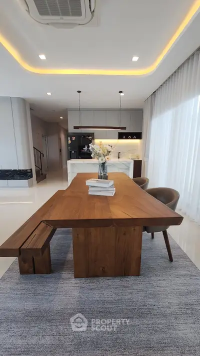 Modern dining area with wooden table and elegant kitchen in open layout