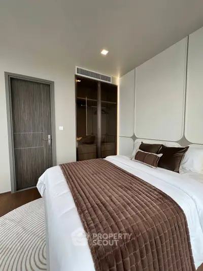 Luxurious bedroom with elegant decor and plush bedding in modern apartment.