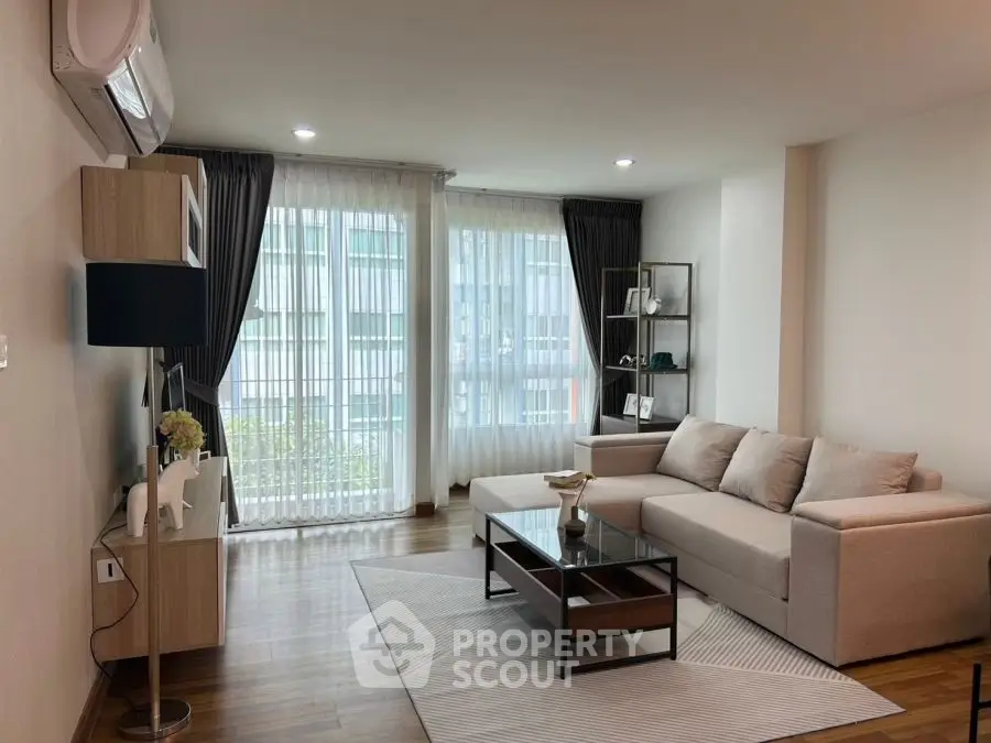 Modern living room with large windows, stylish furniture, and elegant decor.