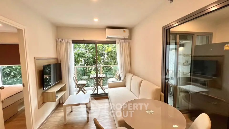 Modern living room with balcony view, featuring cozy seating and stylish decor.