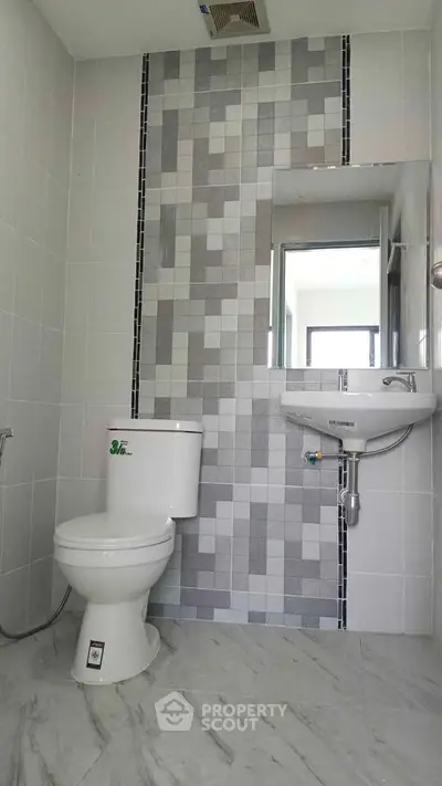 Modern bathroom with stylish tile design and compact fixtures