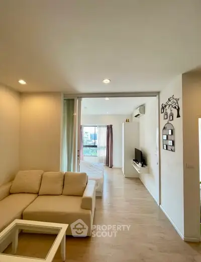 Spacious modern living room with cozy beige sofa and open layout design.