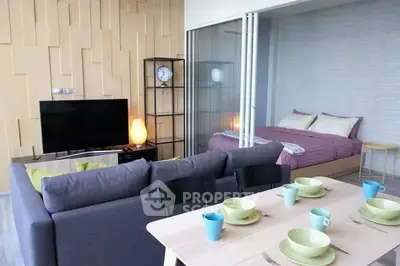 Modern open-plan living room with stylish decor and cozy bedroom area.