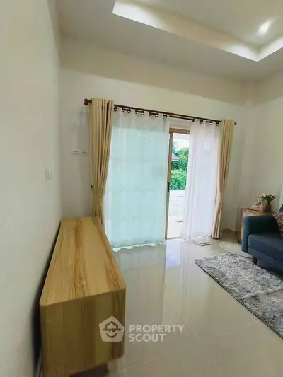 Bright living room with modern furniture and large window view.