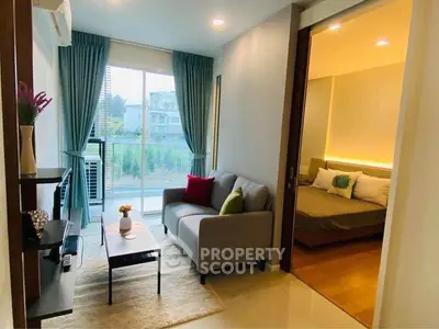Modern living room with cozy sofa and view of bedroom, perfect for urban living.