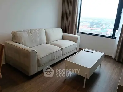 Cozy living room with a comfortable sofa and a scenic window view, perfect for relaxation.