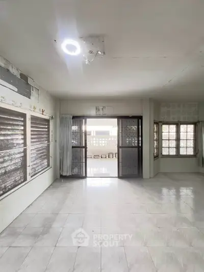 Spacious empty room with large windows and natural light