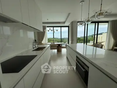 Luxurious modern kitchen with open layout and stunning view, featuring sleek white cabinetry and elegant lighting.
